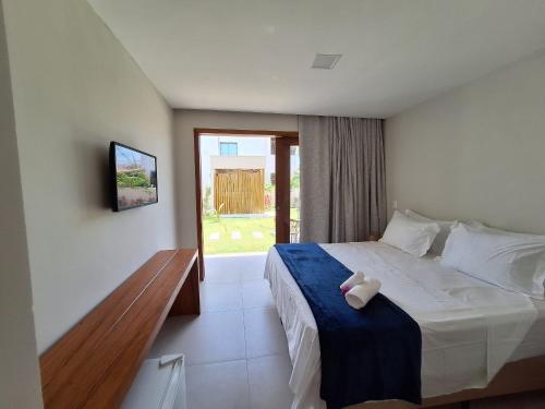 a bedroom with a bed with a blue blanket at Pousada Oasis dos Ventos - São Miguel do Gostoso in São Miguel do Gostoso