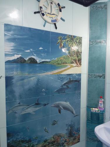 a bathroom with a mural of dolphins in the water at Apartament ALBATROS in Burgas City