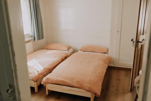 two beds in a small room with a window at Familien-Chalet am Alpstein für Gruppen bis 12 Personen und Familien, Appenzell Premium Privatunterkunft im Ski- und Wandergebiet Hoher Kasten in Brülisau