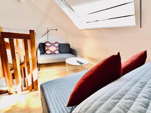 a bedroom with a bed with red pillows and a couch at Logies by Suzan in Hasselt