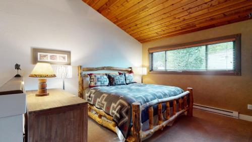 a bedroom with a wooden bed and a window at Bridgepoint Condo 24 in Ketchum