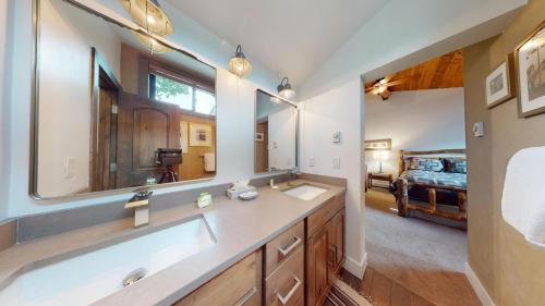 a bathroom with a sink and a mirror and a bed at Bridgepoint Condo 24 in Ketchum