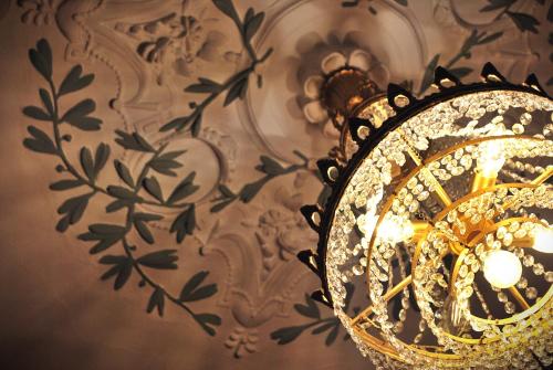 a chandelier hanging from a wall with a floral pattern at B&B La Sucrerie in Amougies