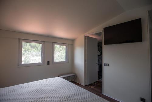 a bedroom with a bed and a flat screen tv at Casa da Eira Velha in Chaves
