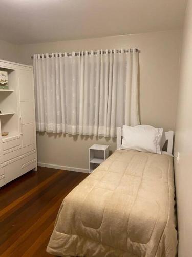 a bedroom with a large bed and a window at Sítio das Flores - 4 quartos - 8 a 10 pessoas in Garibaldi