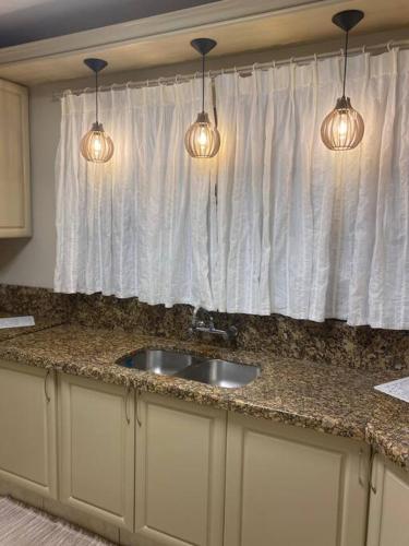 a kitchen with a sink and a window with lights at Sítio das Flores - 4 quartos - 8 a 10 pessoas in Garibaldi