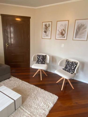 two chairs and a table in a living room at Sítio das Flores - 4 quartos - 8 a 10 pessoas in Garibaldi