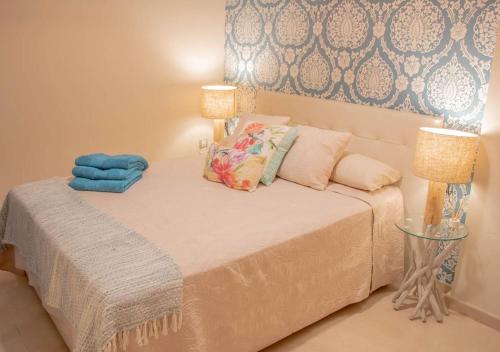 a small bedroom with a bed with two lamps at Apartamento Boutique TOKIO in Garrucha