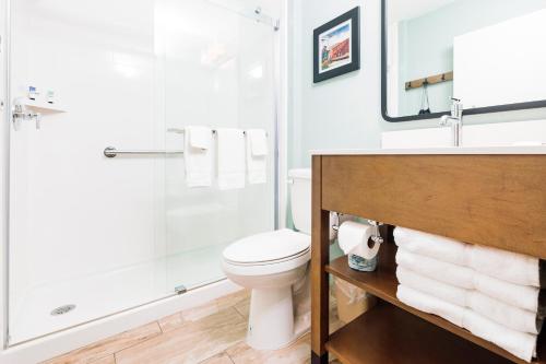 a bathroom with a toilet and a shower and a sink at The Windstar Hotel - Carolina Beach in Carolina Beach