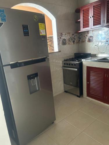 a kitchen with a refrigerator and a stove at Casa frente al centro comercial in Montería