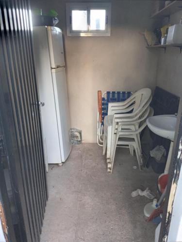 a kitchen with chairs and a refrigerator and a table at CAMPING DON EMILIO in Lobos