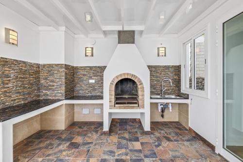 a kitchen with a brick fireplace in a house at Casa Conchi Puerto del Carmen in Puerto del Carmen