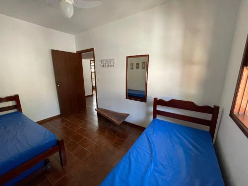 a bedroom with two beds and a mirror in it at Caribean Praia das Toninhas - A 100 metros da areia 21A in Ubatuba