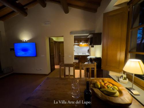 a kitchen with a table with a bowl of bananas at Poolhouse Oasi del Lupo in Subbiano
