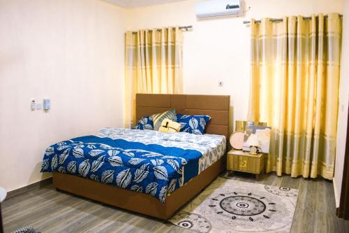 a bedroom with a bed with a blue comforter at Adji's Cozy Villa in Apenkwa