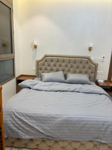 a bedroom with a large bed with blue pillows at شقه مفروشه مميزه 3 in Obhor