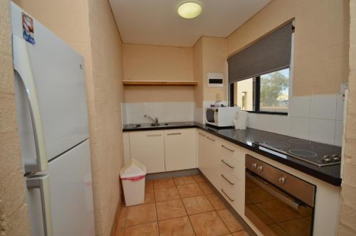een kleine keuken met een koelkast en een wastafel bij Riverview Holiday Apartment 67 - Kalbarri WA in Kalbarri