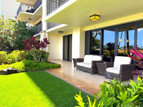 a patio with wicker chairs and a lawn at Luxury Pool front Ko Olina Beach Rental Ground Floor B105 2BR free parking in Kapolei