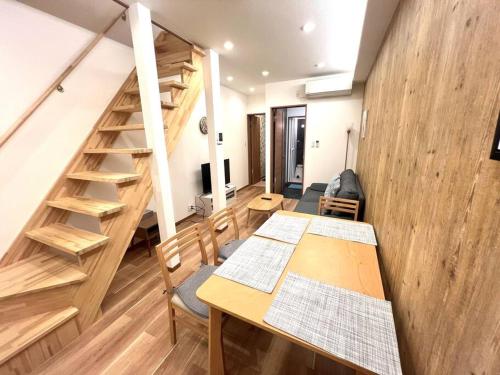 a room with a table and a staircase in a room at Sunrise house JU in Osaka