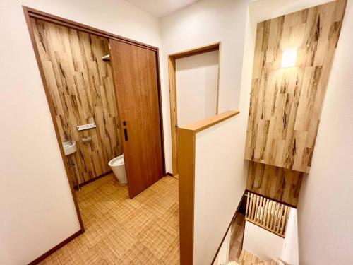 a bathroom with a door and a toilet in it at Sunrise house JU in Osaka