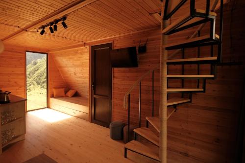 a wooden cabin with a spiral staircase in it at Outside Kazbegi in Stepantsminda