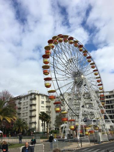 a large ferris wheel in front of a building at Hôtel Bosquet Pau Centre - Self Check In Budget Hotel in Pau