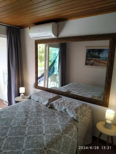 a bedroom with a large mirror and a bed at Flat 207 Villa Hípica - Gravatá in Gravatá