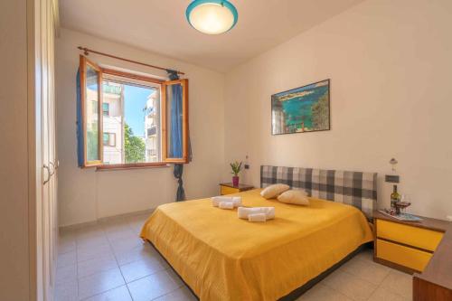 a bedroom with a bed with yellow sheets and a window at Holiday home in Alghero 44952 in Alghero