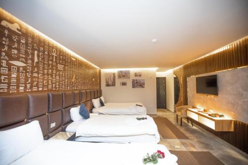 a hotel room with two beds and a tv at New Comfort Inn Giza in Cairo