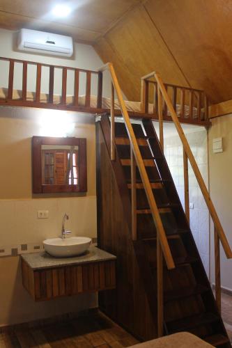 a bathroom with a sink and a wooden staircase at Pousada e Camping Carrion in Itu
