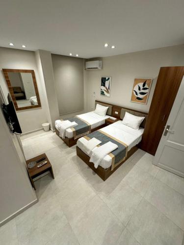 a hotel room with two beds and a mirror at October Square in 6th Of October