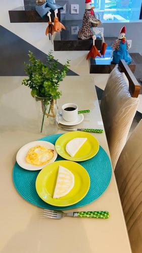 a table with plates of food and a cup of coffee at Pousada Musa do Porto in Porto De Galinhas