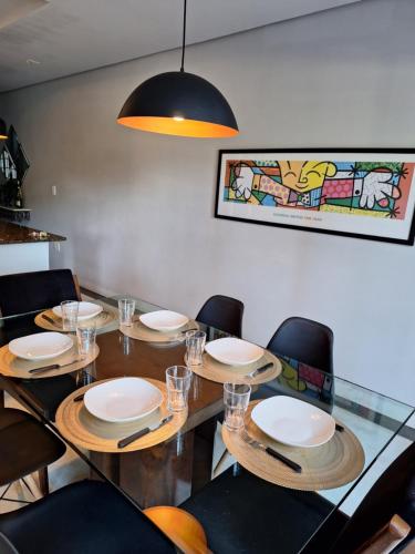 a dining room with a table with plates and chairs at Casa Alto Da Boa Vista Com Piscina e Churrasqueira in São Paulo