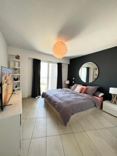 une chambre avec un grand lit et un grand miroir dans l'établissement Appartement Montpellier, à Montpellier
