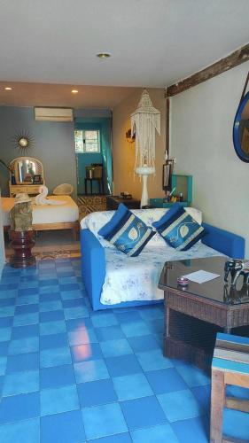 a bedroom with two beds and a table at Baan sikhao Yanui in Rawai Beach