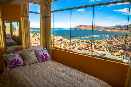 a bed in a room with a large window at Wisny Inn in Puno