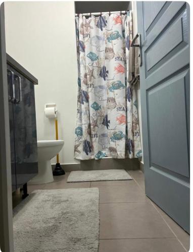 un bagno con tenda da doccia e lavandino di Cozy Apt a Koolbaai