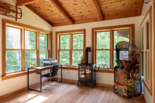 a home office with a desk and windows at Iron Gate Chalet - 5 Minutes to Smugglers Notch! in Cambridge
