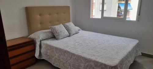 ein Schlafzimmer mit einem Bett mit weißen Laken und einem Spiegel in der Unterkunft Habitación Matrimonio cerca a la Playa de Poniente in Benidorm