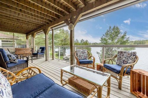 eine abgeschirmte Veranda mit Stühlen und einem Tisch in der Unterkunft Muskoka Lakeshore Cottage Bliss in Gravenhurst