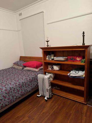 a bedroom with a bed and a book shelf at Ashburton big Room with shared bathroom 1 in Chadstone