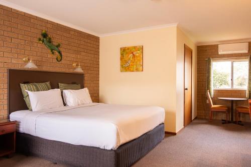a hotel room with a large bed and a window at Hepburn Springs Motor Inn in Hepburn Springs