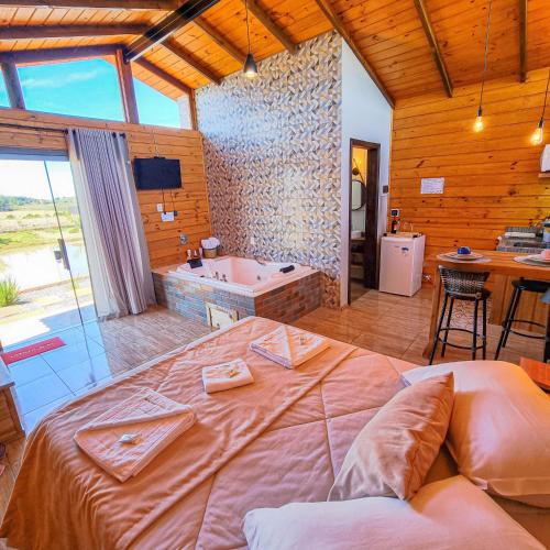 a bedroom with a large bed and a bath tub at Cabanas Colina Do Sol in Cambará