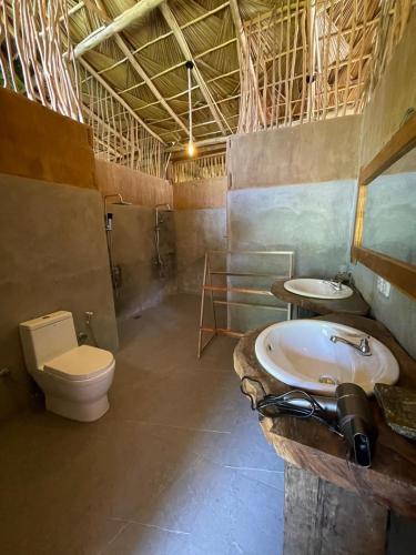 a bathroom with a toilet and a sink at Wood Palace Ella in Ella