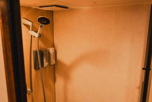 a shower in the corner of a room at Hakuba Pension & Log Hotel Meteor in Hakuba