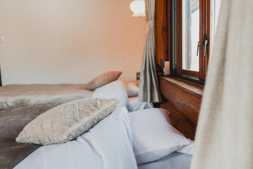 a bedroom with two beds and a window at Hakuba Pension & Log Hotel Meteor in Hakuba