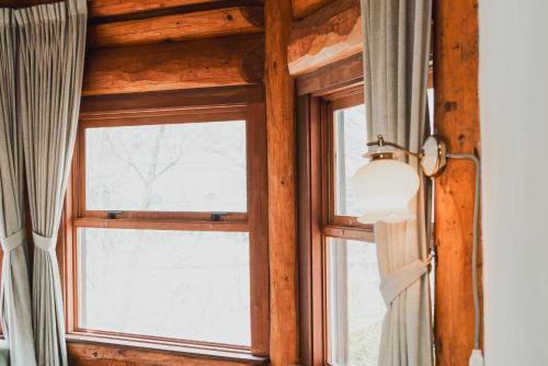 a window in a room with a view of the snow at Hakuba Pension & Log Hotel Meteor in Hakuba