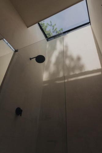 a shower with a glass door with a window at Casa Ocaso in Palomino