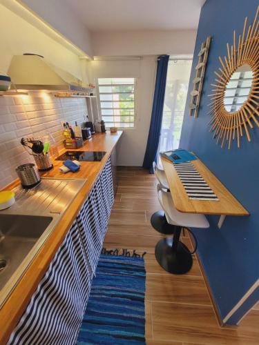 a kitchen with a counter and a blue wall at MY SWEET HOME Location - Feel Unique, Stay Unique in Faaa