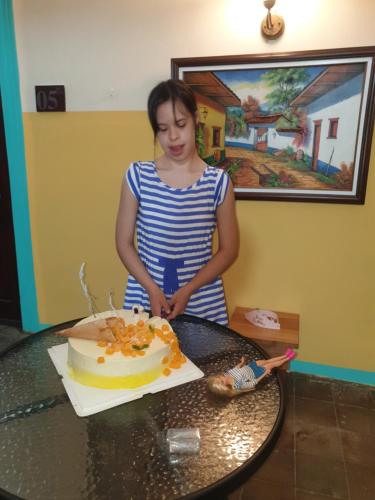 a young girl cutting a cake on a table at Hotel Liberia in Liberia